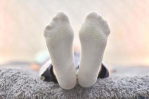 Woman resting on sofa in white striped socks, close up. photo