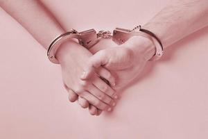 Male and female hands in handcuffs. Love forever. photo