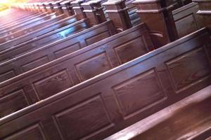 Cathedral pews. Rows of benches in christian church. Heavy solid uncomfortable wooden seats. photo