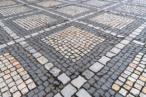 Tiles texture. Pattern of ancient german cobblestone in city downtown. Little granite paving stones. Antique gray pavements. photo