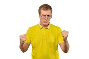 chico geek infeliz con gafas y camiseta amarilla listo para pelear con puños fondo blanco aislado foto