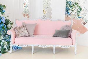 Beautiful luxury classic clean interior living room in white color with pink sofa flower composition. Bright modern stylish interior living room with furniture in classic minimalist style. photo