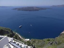 White buildings on the cliff and blue aegean seascape at santorini island photo