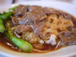 close-up stir fried rice noodle with beef and kale gravy sauce cantonese style photo