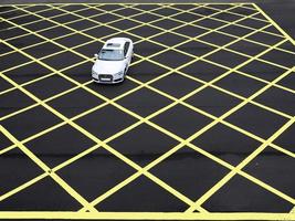 A car drive through the asphalt road which painted in Yellow line geometric shape square grid pattern of line marking photo