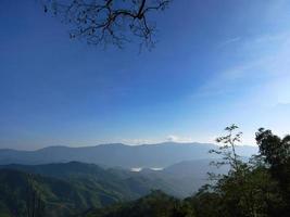 paisaje de hermosas montañas matutinas en tonos de capa y cielo azul brillante para papel tapiz foto