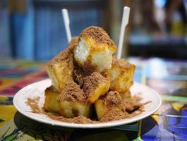 Close up Stack of crispy crunchy cube shape bread with butter, sprinkle on top with cocoa powder, dessert snack, food wallpaper with blurry background photo