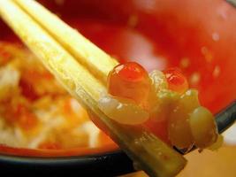 a pair of wooden chopsticks with last word salmon roe food from the empty bowl photo