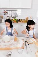 cerrar hermanita hacer un horneado en la cocina foto