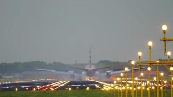 Airliner landing on the runway in a crosswind with it's fuselage slightly skewed. View from the edge of the runway behind ALS masts. video