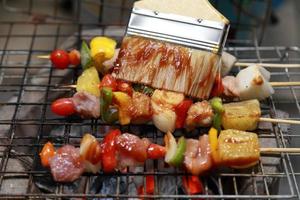 Close up  assorted delicious grilled meat with vegetables over the coals on a barbecue photo