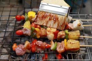 cierre una deliciosa carne a la parrilla variada con verduras sobre las brasas en una barbacoa foto