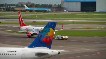 amsterdam, países bajos 29 de julio de 2017 - smallplanet airlines airbus a320 ly spa rodando después del aterrizaje, y corendon boeing 737 push back, aeropuerto shiphol, amsterdam, holanda video