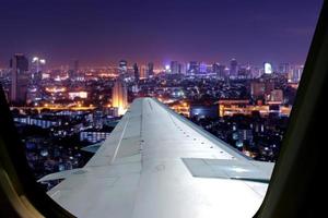 Evening flight on twilight sky, amazing view from the window plane. Window seat on airplane overlooking  city at night view . photo