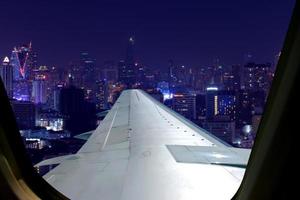 vuelo nocturno en el cielo crepuscular, vista increíble desde el avión de la ventana. asiento de la ventana en el avión con vistas a la ciudad por la noche. foto