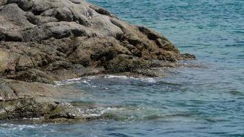 turquoise golven rolden op de rotsen, nai harn strand ten zuiden van phuket eiland, slow motion video