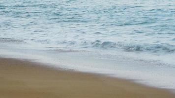 ondas em uma praia de areia. praia de maio khao no norte de phuket, câmera lenta video