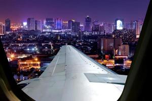 Evening flight on twilight sky, amazing view from the window plane. Window seat on airplane overlooking  city at night view . photo