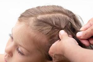 manos trenzas trenzas en la cabeza del niño foto