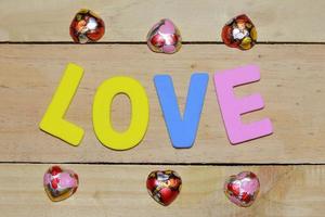 cartas de amor y corazón de chocolate en el suelo de madera. fondo del día de san valentín con corazones. concepto de San Valentín. espacio para texto. foto