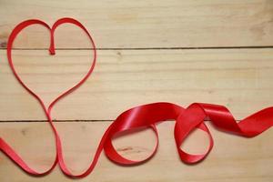 Design Red heart shaped ribbon awareness on old aged wood background. valentine concept. Space for text. photo