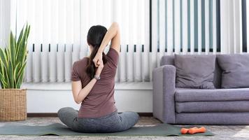 A calm girl stretching her whole body touching the tip of a leg after workout photo