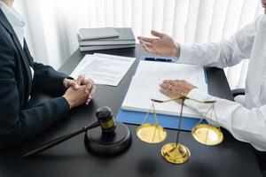 law,libra scale and hammer on the table, 2 lawyers are discussing about terms and condition, law matters determination photo