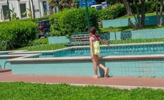 Cattolica Italy 2022 Little girl playing and refreshes her hands with jets of water photo