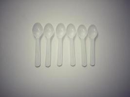 White plastic spoon white background gives the concept of disposable plastic that pollutes the environment.  Affecting global warming photo