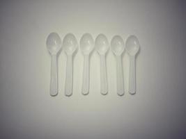 White plastic spoon white background gives the concept of disposable plastic that pollutes the environment.  Affecting global warming photo