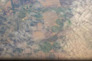 Aerial photo of Farmland. view from the plane to the ground. squares of fields under the clouds