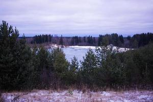 Summer landscape with a beautiful lake with fir trees and forested mountains against a cloudy sky photo