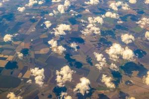 foto aérea de tierras de cultivo. vista desde el avión hasta el suelo. cuadrados de campos bajo las nubes