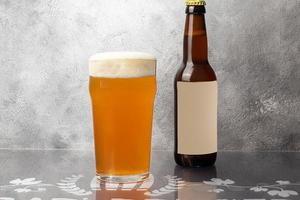 Glasses with different types of craft beer on a wooden bar. In glasses and bottles. Nuts and crackers on the table. On a dark background. photo