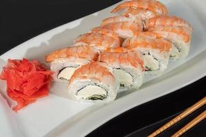 Sushi sets Uramaki, California, Philadelphia, rolls on a white plate. Menu for restaurants, cafes. On a dark reflective background. photo