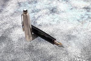 Fountain pen on a marble and gray background. Selective focus. photo