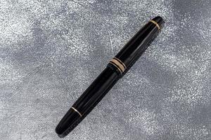 Fountain pen on a marble and gray background. Selective focus. photo