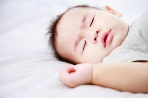 baby sleeping on the bed in the home during the daytime, Close-up shot photo