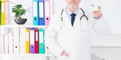 Doctor hold business card in clinic, medical insurance, man in white uniform. Copy space photo