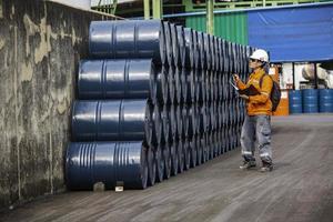 Registro de inspección del trabajador masculino barriles de stock de aceite de tambor azul horizontal o químico foto