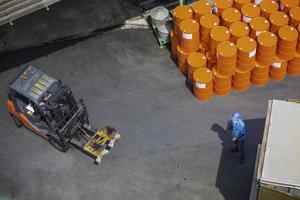 movimiento de carretilla elevadora de barriles de petróleo en el camión de transporte foto