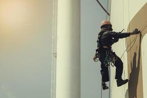 Male worker rope access height safety inspection of thickness storage oil and gas tank photo