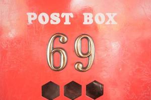 red mailbox with 69 number on the wall photo