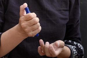 Woman hands holding lancet to prick finger to check sugar in blood photo