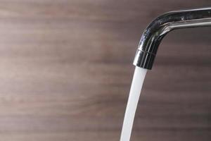 close up of faucet with flowing water photo