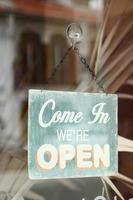 Open sign hanging front of cafe . photo