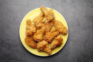 Crispy fried chicken wings on a plate top view . photo