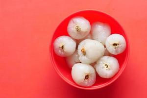 Lychee on in a bowl on red background photo