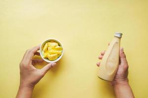 mango smoothie and fresh mango on yellow background photo