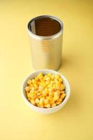 Sweet corns in a bowl and tin container on table photo